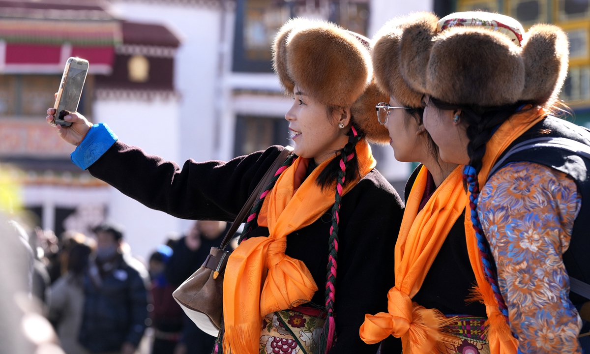 Locals dressed in their finest traditional attire take a selfie at the Jokhang Temple in Lhasa, Xizang Autonomous Region on December 1, 2025. Locals gathered outside the temple to welcome the upcoming Pal Lhamo Festival, which falls on the 15th day of the 10th month of the Tibetan calendar. Photo: VCG