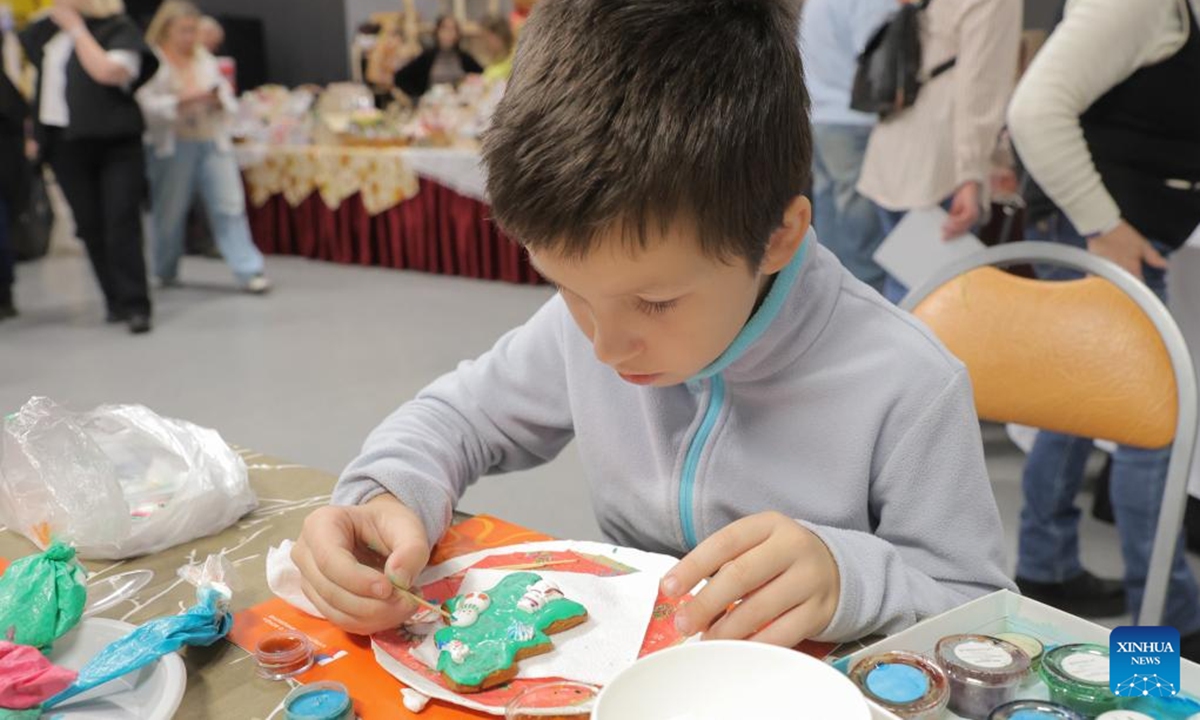 A child experiences making gingerbread cookies during the 10th Gingerbread World International Art Festival in St. Petersburg, Russia, Nov. 30, 2025. (Photo by Irina Motina/Xinhua)