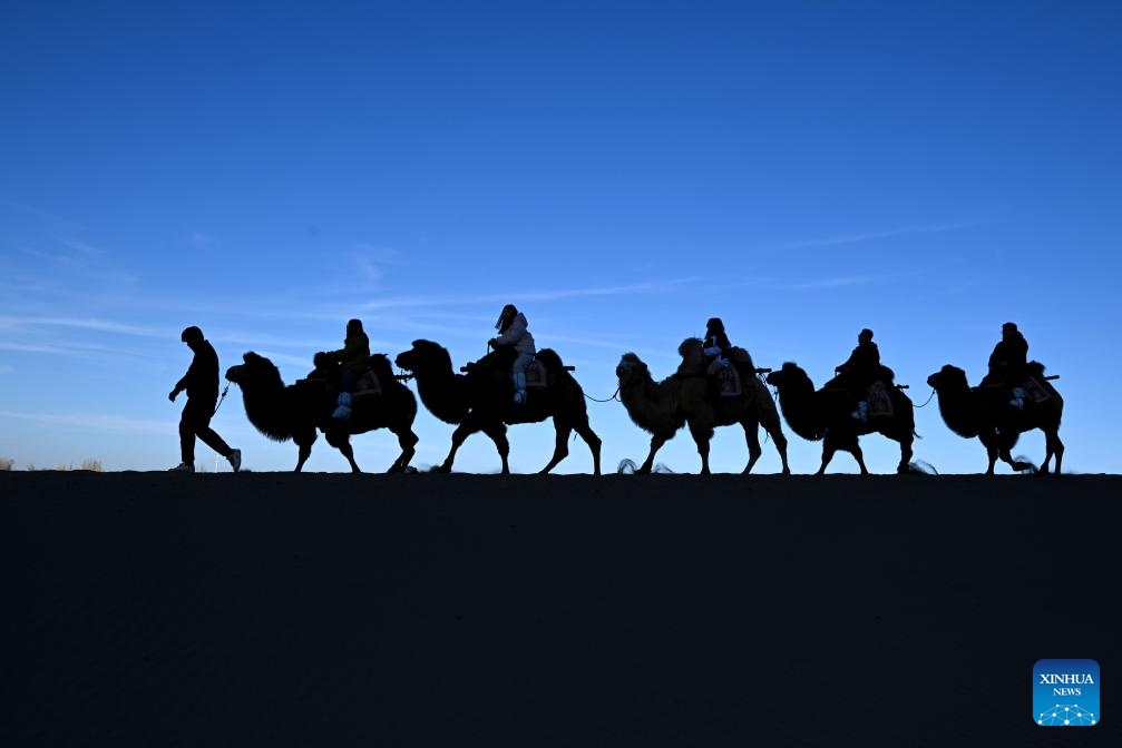 Tourists visit the Mingsha Mountain and Crescent Spring Scenic Area in Dunhuang City, northwest China's Gansu Province, Nov. 30, 2025. (Photo by Zhang Xiaoliang/Xinhua)