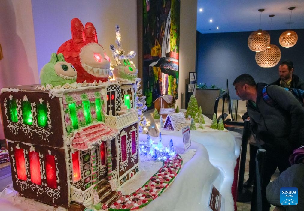 People look at gingerbread house creations during the annual Gingerbread Lane event in Vancouver, British Columbia, Canada, Nov. 29, 2025. Canada's longest-running gingerbread house display event returned for its 33rd year, featuring more than 30 gingerbread houses and inviting the public to vote for their favourite creations crafted by professional bakers, culinary artists, and culinary school students. (Photo by Liang Sen/Xinhua)