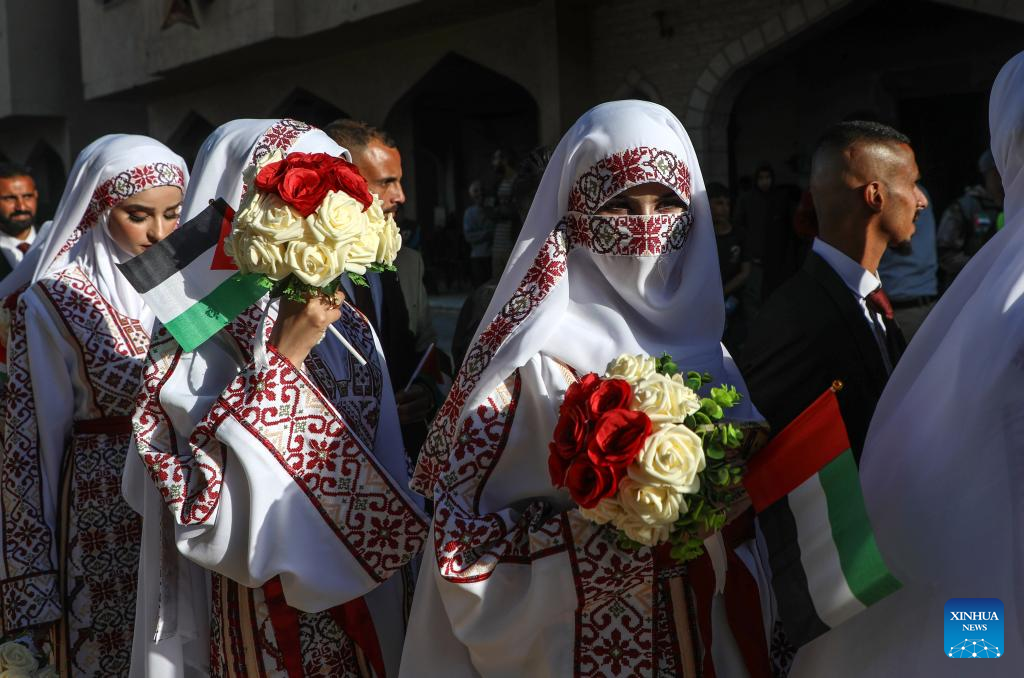 Palestinian grooms and brides celebrate together a mass wedding in the southern Gaza Strip city of Khan Younis, Dec. 2, 2025. Fifty-four couples attended the event. (Photo by Rizek Abdeljawad/Xinhua)