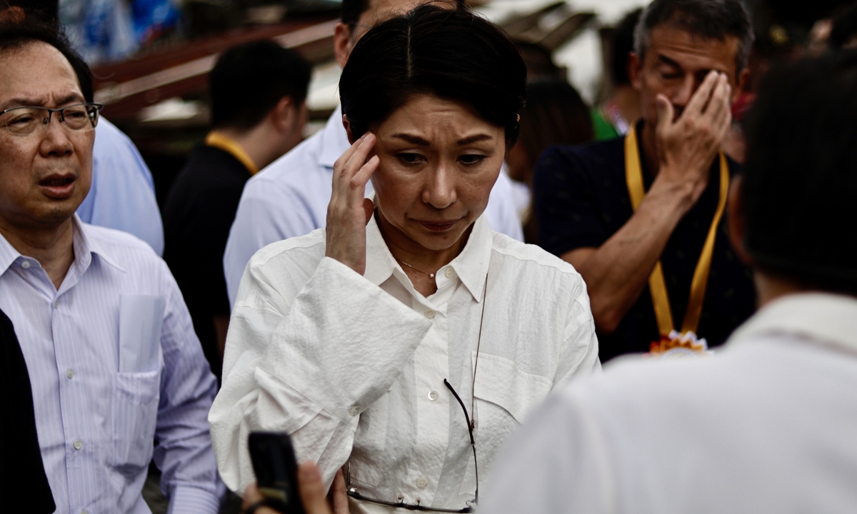 Yuko Obuchi (C), a member of the Japanese House of Representatives, reacts while viewing an image from a mobile phone during a visit at a flood-prone community in Navotas City, Metro Manila, Philippines, August 28, 2025. Photo: VCG