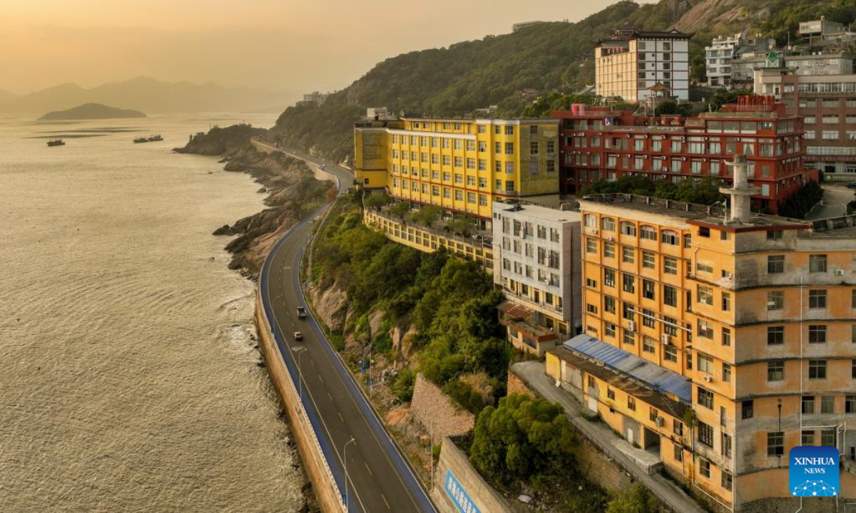 An aerial drone photo shows a view along the coastal road for sightseeing in Sansha Town, Xiapu County, southeast China's Fujian Province, Dec. 3, 2025. Sansha Town in Xiapu County, blessed with unique natural resources and rich historical culture, has been walking a distinctive path to rural revitalization by orchestrating tourist attractions such as high-end homestays, tidal flat landscape and local specialty food with rural development. (Xinhua/Wei Peiquan)