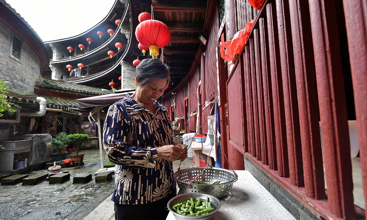 A resident picks vegetables within a Tulou building in Longyan, Fujian Province. Photo: VCG