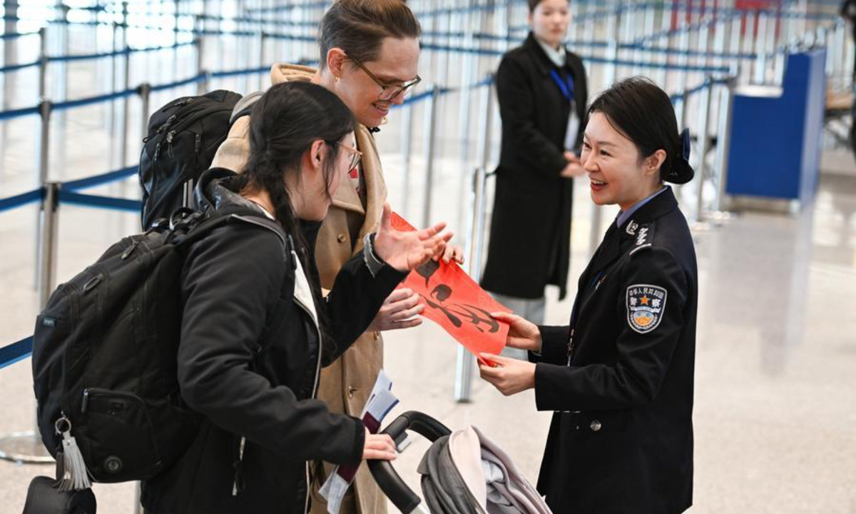 Tourists receive a Spring Festival decoration carrying the Chinese 