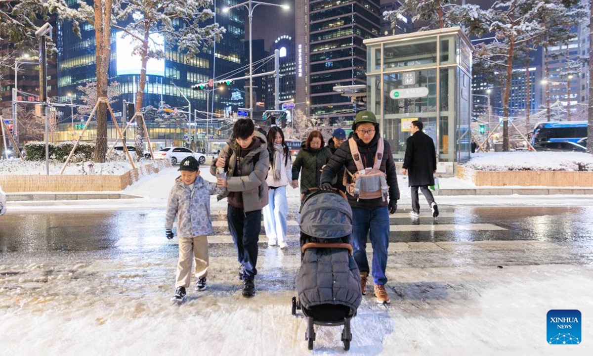 People walk in snow in Seoul, South Korea, on Dec. 4, 2025. Seoul on Thursday saw its first snowfall of this year. (Photo by Park Jintaek/Xinhua)