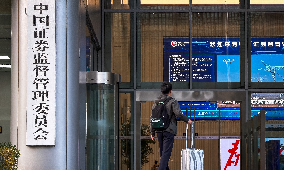 A man with a suitcase walks into the building of the China Securities Regulatory Commission in Beijing on November 12, 2025. Photo: VCG