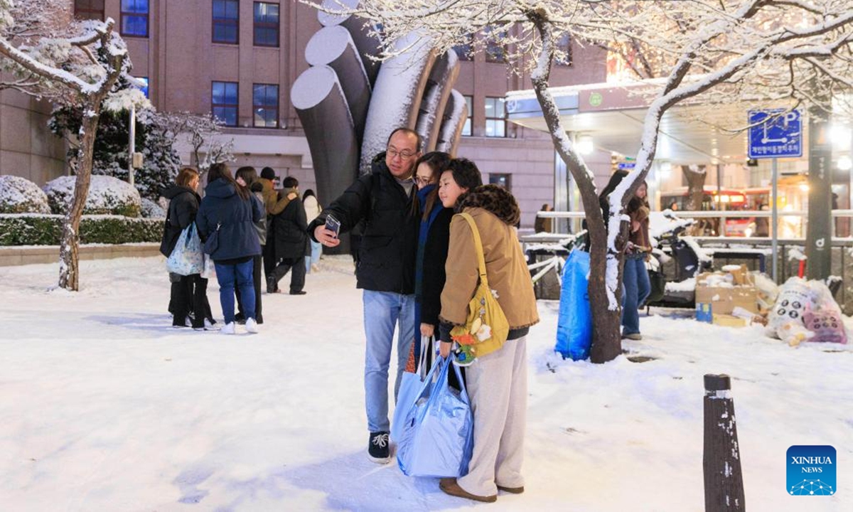 People take selfies in Seoul, South Korea, on Dec. 4, 2025. Seoul on Thursday saw its first snowfall of this year. (Photo by Park Jintaek/Xinhua)