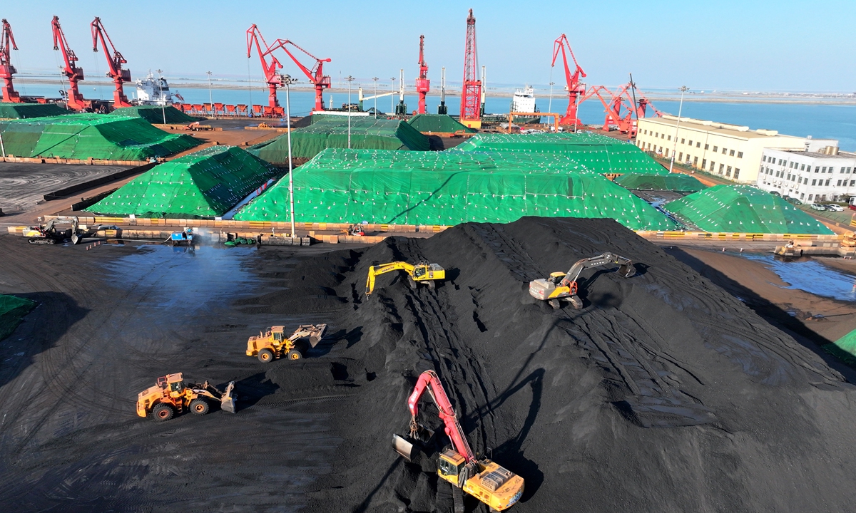 Large machinery and trucks stack and move reserves of thermal coal at the coal terminal of Lianyungang Port in East China's Jiangsu Province on December 5, 2025. As winter sets in, the port is stepping up thermal coal transportation, opening a 