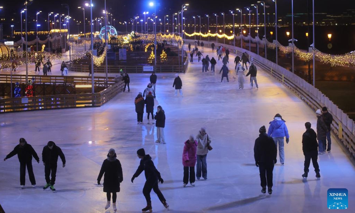 People skate at the Flagpole ice rink in St. Petersburg, Russia, on Dec. 6, 2025. St. Petersburg's Flagpole ice rink officially opened for the season on Saturday. Situated along the Gulf of Finland, the 28,000-square-meter rink is one of the world's largest artificial ice rinks and one of the most popular winter attractions in St. Petersburg. (Photo by Irina Motina/Xinhua)