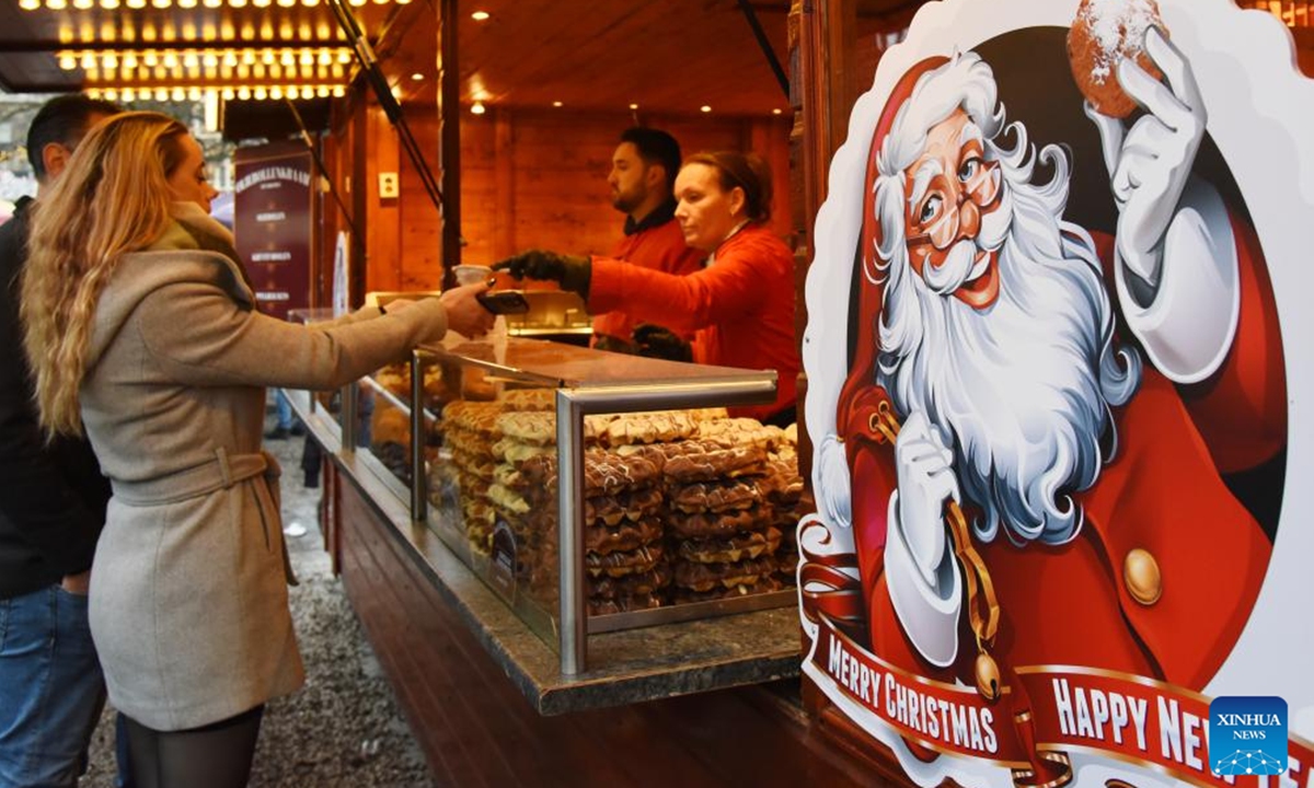 A woman buys food at the Royal Christmas Fair in The Hague, the Netherlands, Dec. 6, 2025. Kicking off here on Dec. 4, the fair will run until Dec. 23. (Xinhua/Shao Haijun)