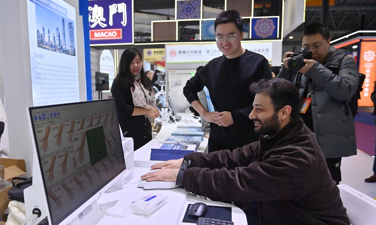 A foreign visitor experiences a traditional Chinese medicine meridian detector at the 2025 Changchun International Medicine and Health Industry Expo in Changchun, Northeast China's Jilin Province, on December 7, 2025. The Expo features AI-powered TCM diagnostic systems, meridian detectors, stair-climbing robots, and other medical and smart living devices, attracting large crowds of visitors. Photo: VCG
