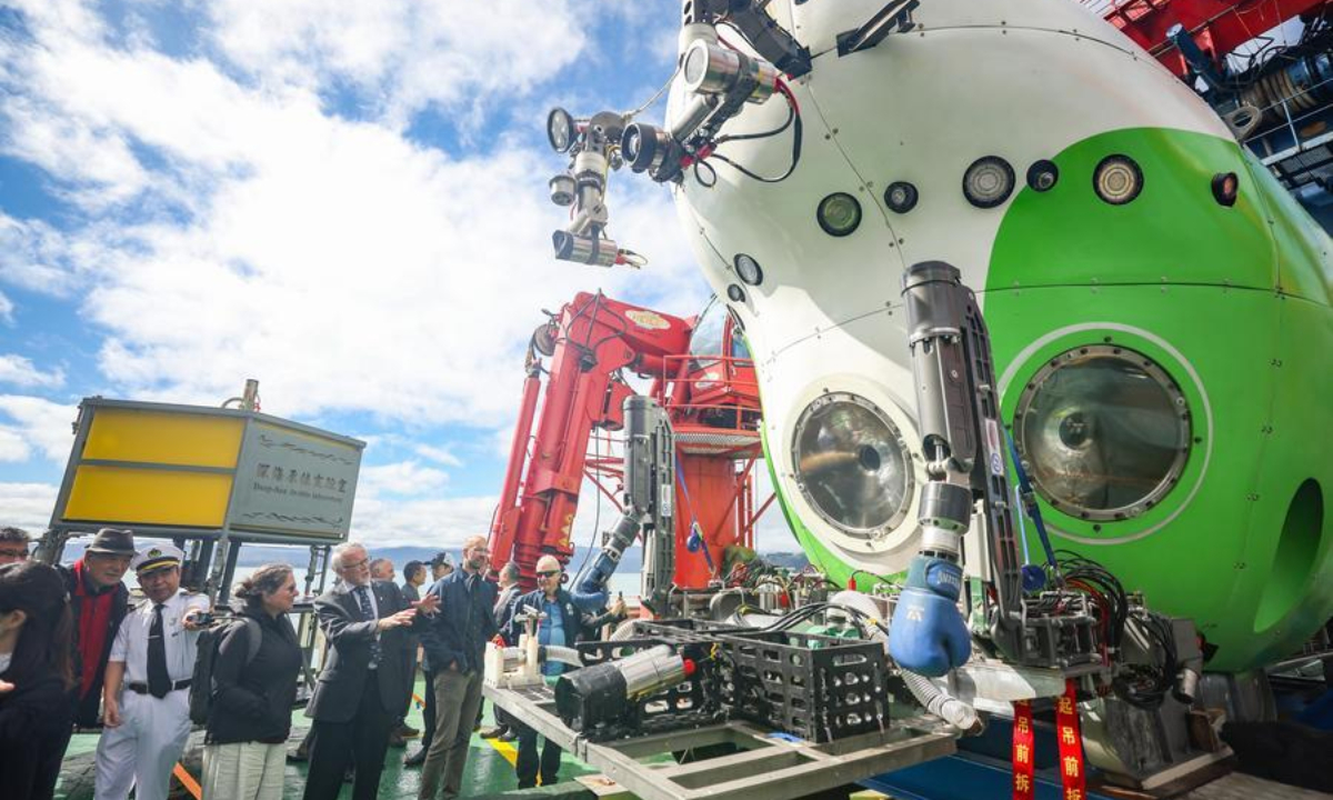 People look at deep-sea manned submersible Fendouzhe (Striver) aboard Tansuo-1 research vessel during a Concluding Open Day of a joint China-New Zealand dive expedition in Wellington, New Zealand, March 21, 2025. (Xinhua/Long Lei)