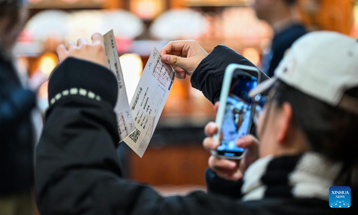 Audience take photos of tickets of Xiangsheng, or crosstalk comedy, at a tea house in north China's Tianjin, Dec. 4, 2025. Crosstalk comedy is a popular form of entertainment for citizens in Tianjin. (Xinhua/Zhao Zishuo)