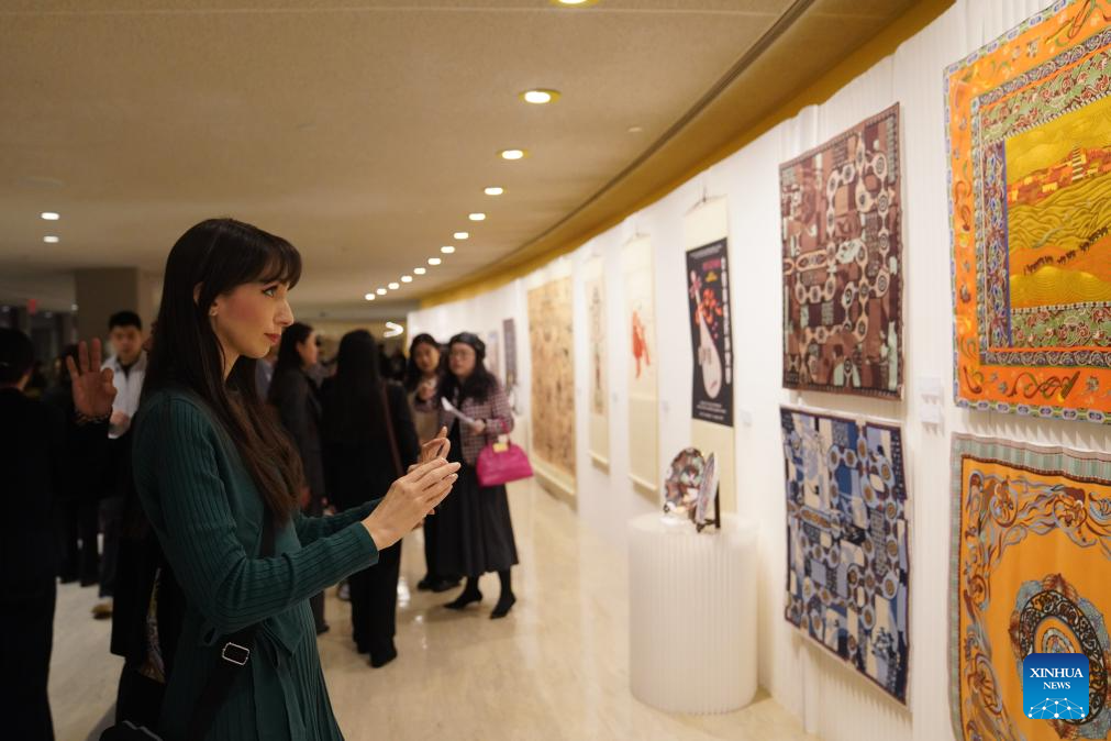 People visit an exhibition showcasing Tsinghua University's research and design work inspired by the ancient art of Dunhuang at the UN headquarters in New York, Dec. 8, 2025. More than 80 works are on display at the exhibition, from early masters such as Pang Xunqin, Chang Sha'na, Chen Hanmin and Liu Jude, to new pieces by Tsinghua students and alumni. (Xinhua/Zhang Fengguo)