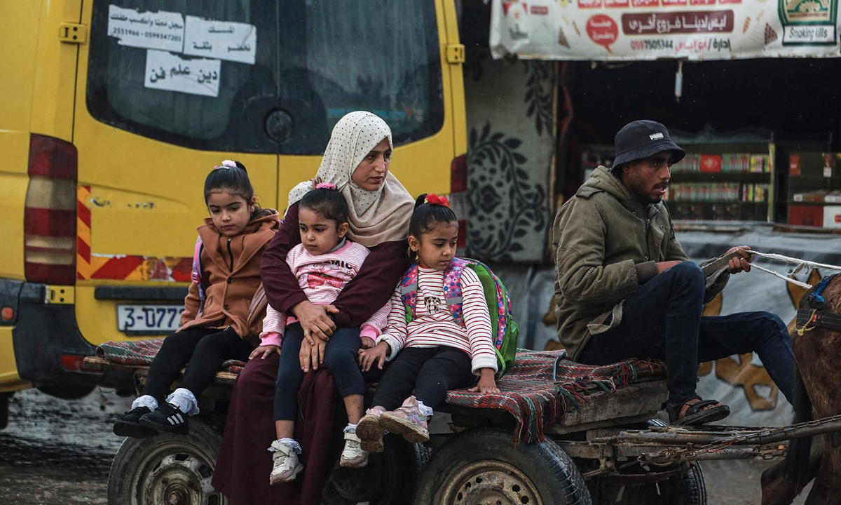 A woman sits on a back of a cart with her children in Deir al-Balah in the central Gaza Strip on December 10, 2025. The US-brokered ceasefire has been in effect since October 10, but both sides have accused each other of daily violations. Photo:VCG