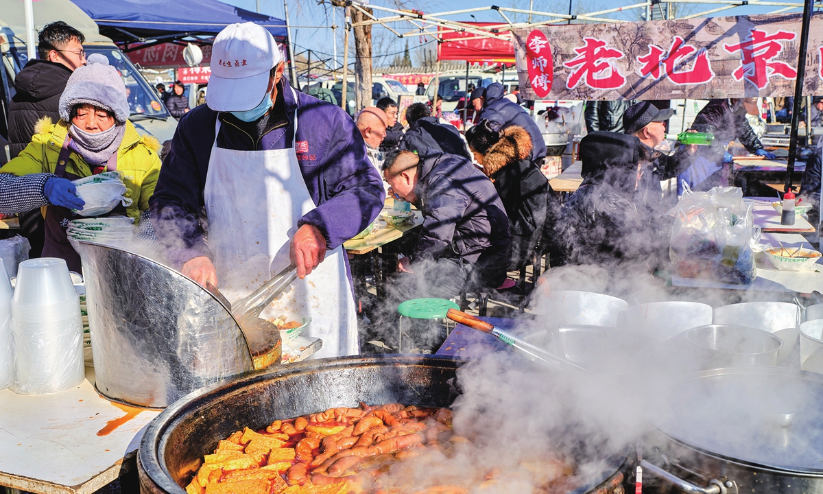 A cook prepares food at a stall at the Sunday Shahe Market in the Changping district of Beijing, one of the capital's largest open-air markets. 