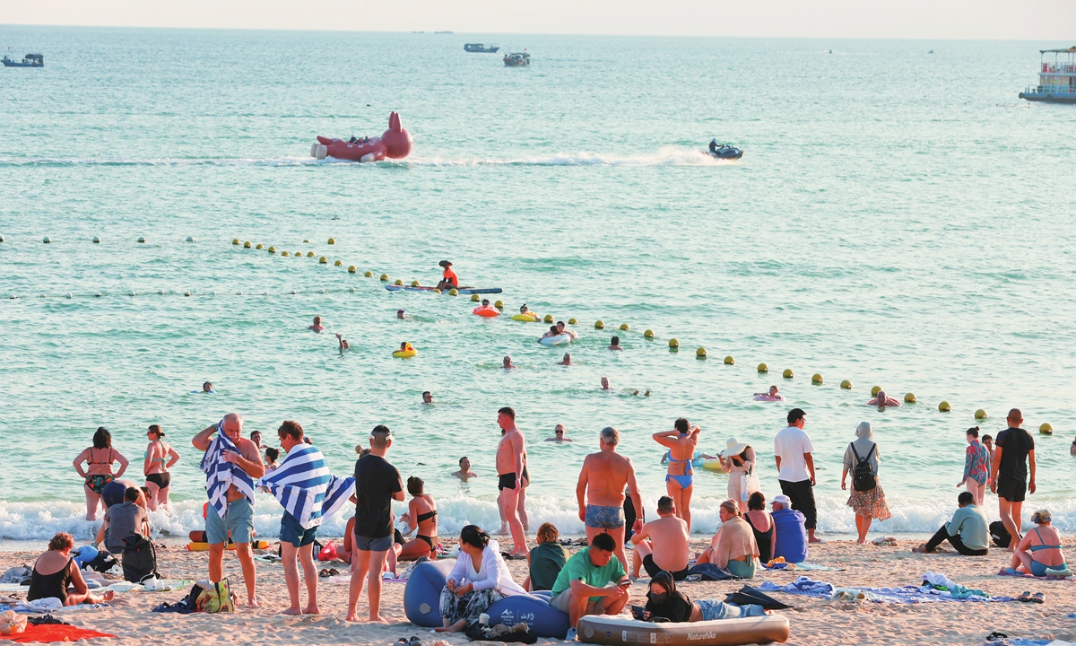 Chinese and overseas visitors unwind on the sands of Dadonghai Beach in Sanya, South China's Hainan Province, basking in the pleasant winter sunshine on December 7, 2025. Photos: VCG