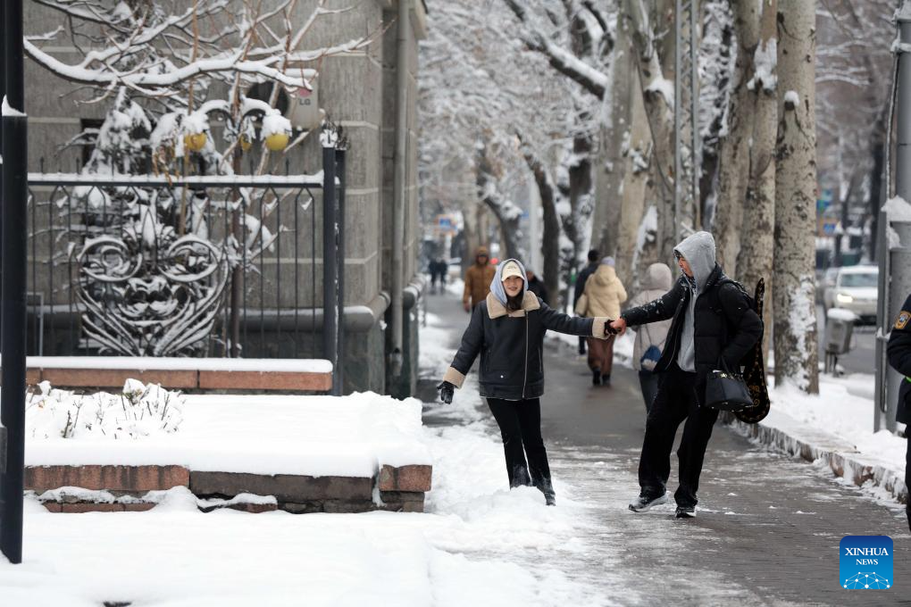 This photo taken on Dec. 10, 2025 shows pedestrians in a street after snow in Bishkek, Kyrgyzstan. (Photo by Roman/Xinhua)