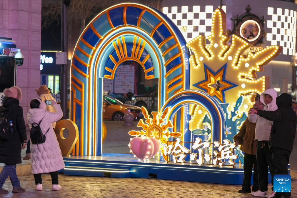 Tourists take photos of an installation on the Central Street in Harbin, capital of northeast China's Heilongjiang Province, Dec. 16, 2025. As one of the most popular attractions in Harbin, the Central Street, which is renowned for its diverse European-style architecture, wows tourists with its ice and snow sculptures and folk shows during the city's tourism boom this winter. (Xinhua/Wang Song)