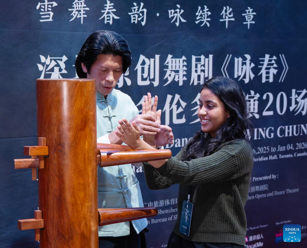 A guest (R) experiences Wing Chun with a wooden dummy during a media day event in Toronto, Canada, on Dec. 15, 2025. The Chinese dance drama will be staged here from Dec. 16, 2025 to Jan. 4, 2026. (Photo by Zou Zheng/Xinhua)
