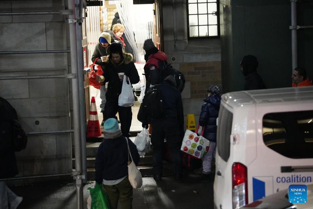 People step out a shelter with free meals in New York City, the United States, Dec. 17, 2025. (Xinhua/Zhang Fengguo)