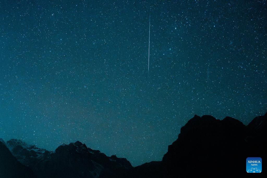 This photo taken on Dec. 14, 2025 shows the Geminid meteor shower in the sky over Yulong Snow Mountain in Lijiang City, southwest China's Yunnan Province. The Geminid meteor shower, one of the most spectacular meteor showers of the year, reached its peak on Sunday. (Xinhua/Hu Chao)