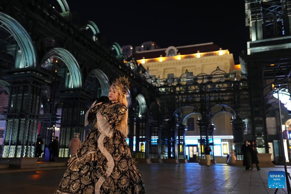 A tourist in costume poses for a photo at a square of architecture art in Harbin, northeast China's Heilongjiang Province, Dec. 15, 2025. The square, where the landmark St. Sophia Cathedral, a former Russian Orthodox church and a perfect example of Neo-Byzantine architectures, is located, has become a hot spot for tourists to take travel photos. (Xinhua/Wang Song)