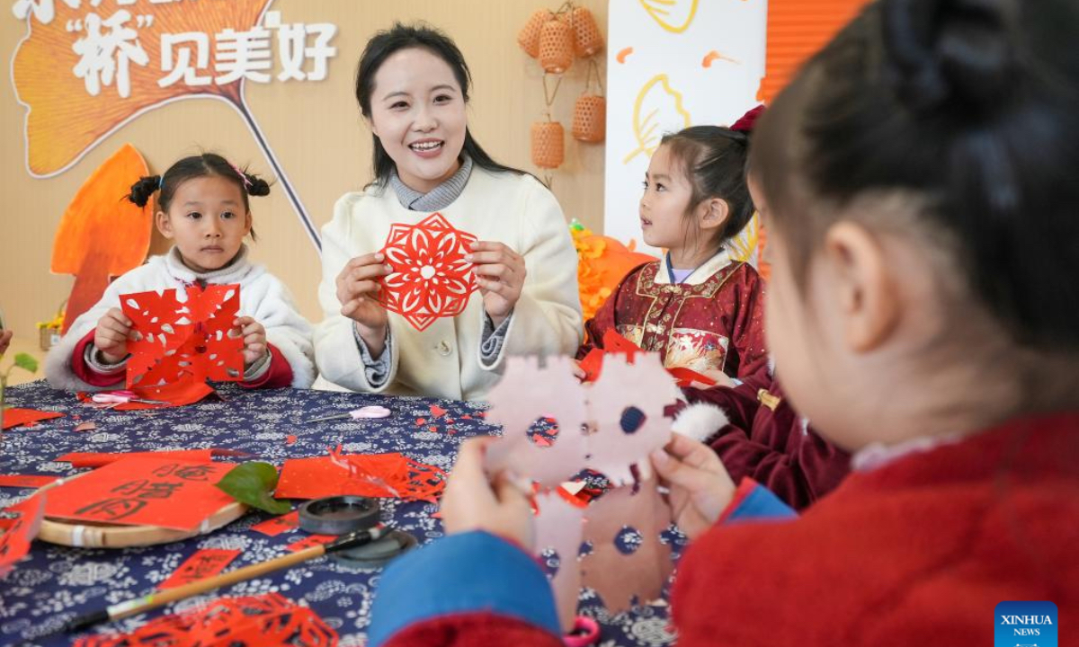 A teacher instructs children to make paper-cutting window decorations at a kindergarten in Taizhou City, east China's Jiangsu Province, Dec. 18, 2025. People all over the country held diverse events on Thursday to mark the Winter Solstice, which will fall on Dec. 21 this year. Winter Solstice, the shortest day of the year, denotes the beginning of deep winter and a break from farming in traditional agricultural society in Chinese culture. Northern China has maintained the tradition of eating dumplings on this day, while people in southern China eat tangyuan (glutinous rice balls). (Photo by Zhou Shegen/Xinhua)