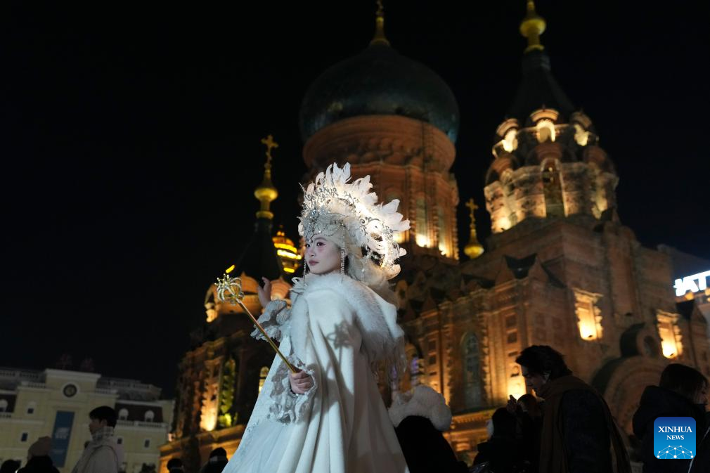 A tourist in costume poses for a photo at a square of architecture art in Harbin, northeast China's Heilongjiang Province, Dec. 15, 2025. The square, where the landmark St. Sophia Cathedral, a former Russian Orthodox church and a perfect example of Neo-Byzantine architectures, is located, has become a hot spot for tourists to take travel photos. (Xinhua/Wang Song)