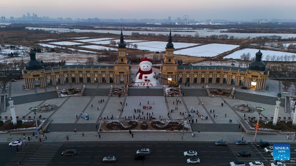 An aerial drone photo shows a giant snowman at the Qunli music park in Harbin, northeast China's Heilongjiang Province, Dec. 15, 2025. This year's giant snowman, 19 meters in height and made with some 3,000 cubic meters of snow, is one meter taller than that of last year. (Xinhua/Wang Song)