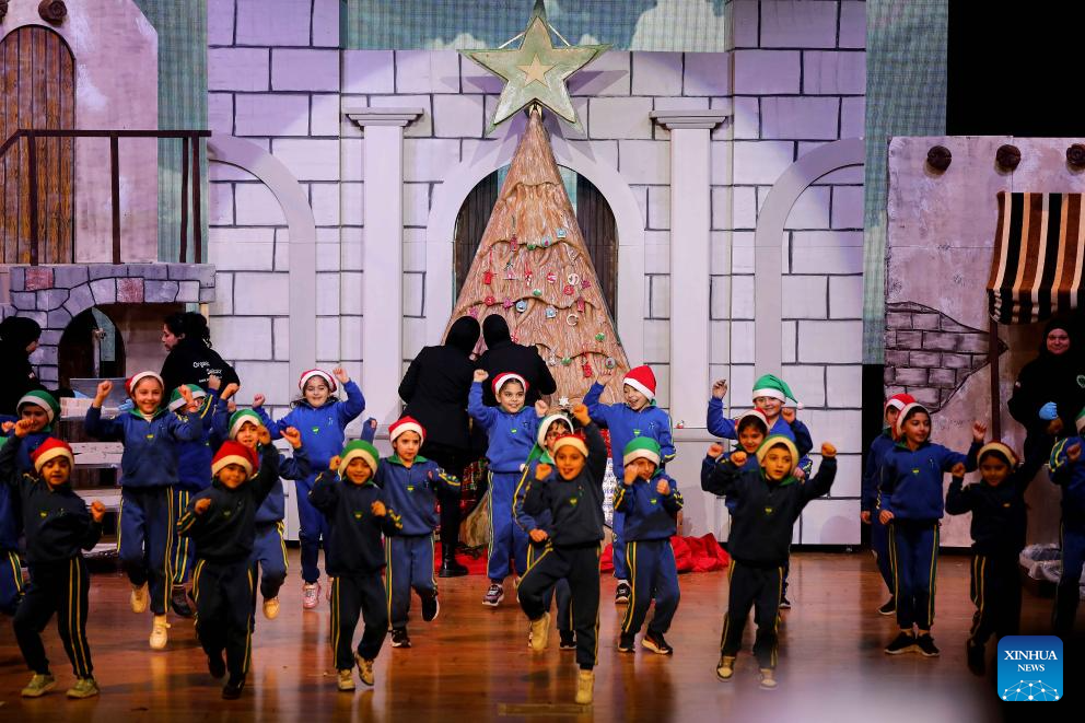 Children celebrate in front of a Christmas tree made from natural soap and aromatic herbs in Beirut, Lebanon, Dec. 15, 2025. This Christmas tree weighs more than 2,000 kilograms and stands 3.5 meters tall. (Xinhua/Bilal Jawich)