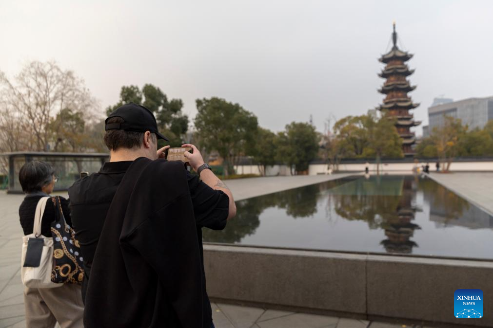 Guests attending the 4th Shanghai International Literature Week take photos of Longhua Pagoda in east China's Shanghai, Dec. 17, 2025. (Xinhua/Wang Xiang)