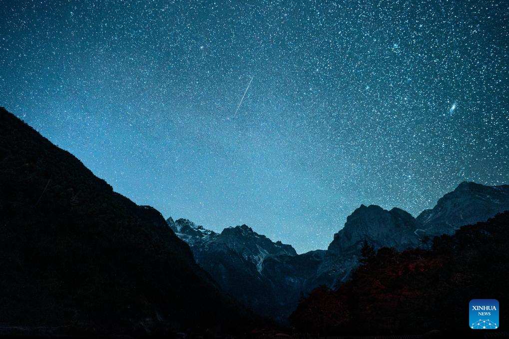 This photo taken on Dec. 14, 2025 shows the Geminid meteor shower in the sky over Yulong Snow Mountain in Lijiang City, southwest China's Yunnan Province. The Geminid meteor shower, one of the most spectacular meteor showers of the year, reached its peak on Sunday. (Xinhua/Hu Chao)