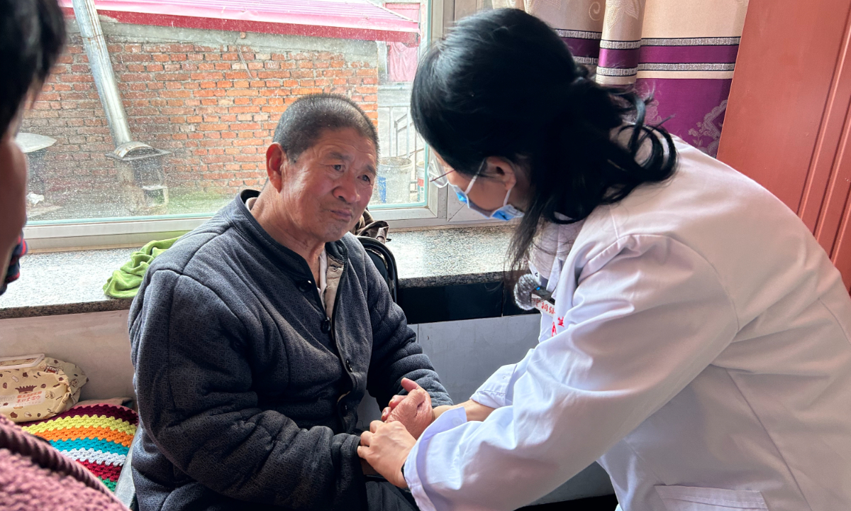 A medical expert expresses care and concern for Duan Shuqin, a senior living with severe disabilities, in Fengning, Hebei, on December 7, 2025. Photo: Liang Rui/GT