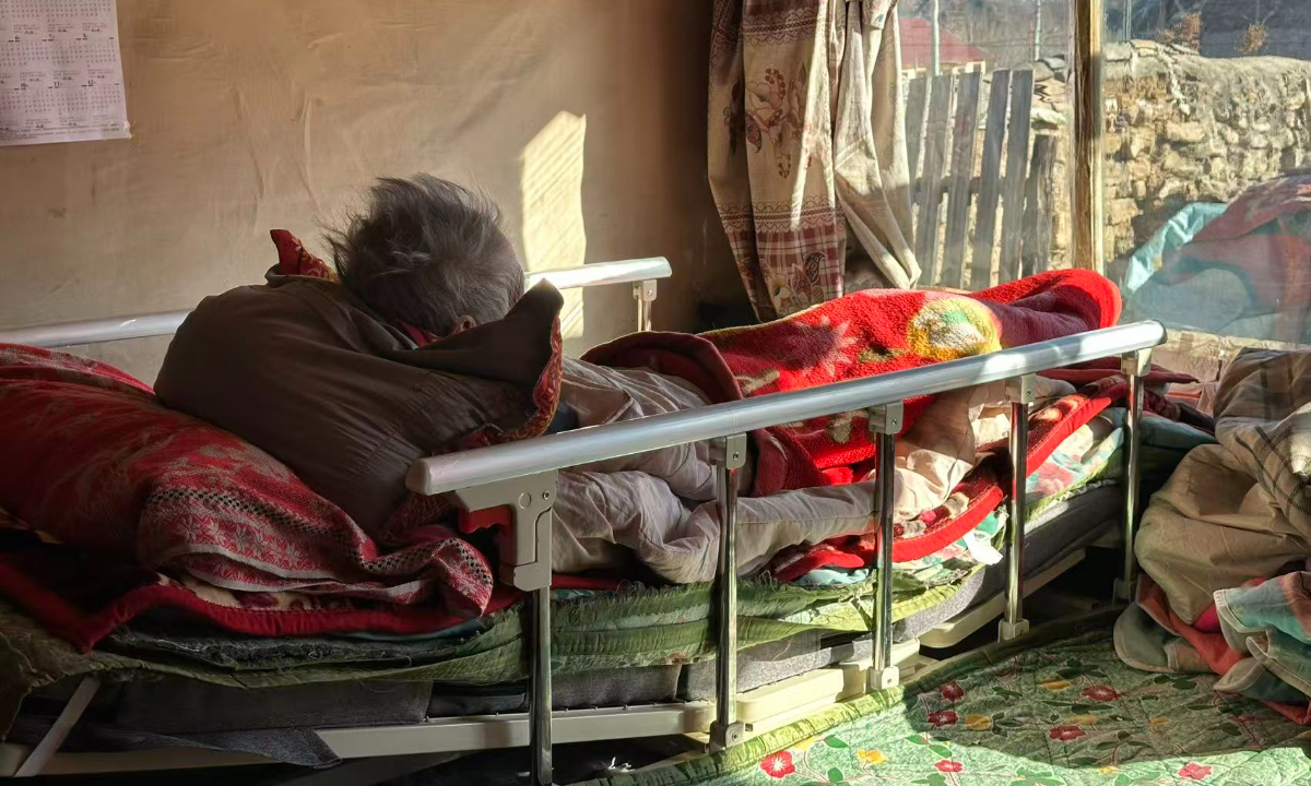 Wu Fenglan lies on a smart bed frame in Fengning, Hebei, on December 8, 2025. Photo: Liang Rui/GT