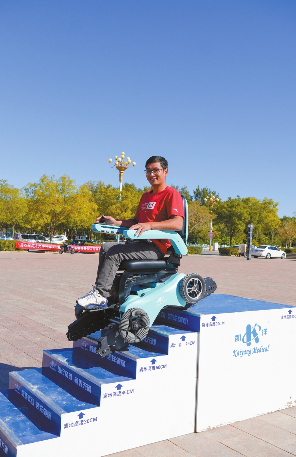 A volunteer tries out an intelligent wheelchair equipped with tank-like tracks. Photo: Courtesy of Liu Yi'an