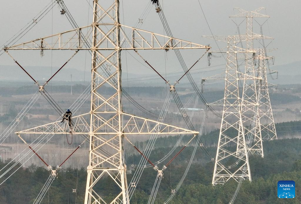 A drone photo taken on Dec. 16, 2025 shows a constructor working on a power transmission line in east China's Anhui Province. The main-body construction of the 500-kV power transmission line from Xiangjian to Ludao in Anhui Province was successfully completed on Wednesday. With a total length of 136.8 kilometers, the line will further optimize the power grid structure of Anhui and enhance power supply reliability upon completion. (Xinhua/Zhou Mu)