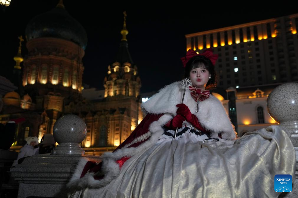 A tourist in costume poses for a photo at a square of architecture art in Harbin, northeast China's Heilongjiang Province, Dec. 15, 2025. The square, where the landmark St. Sophia Cathedral, a former Russian Orthodox church and a perfect example of Neo-Byzantine architectures, is located, has become a hot spot for tourists to take travel photos. (Xinhua/Wang Song)