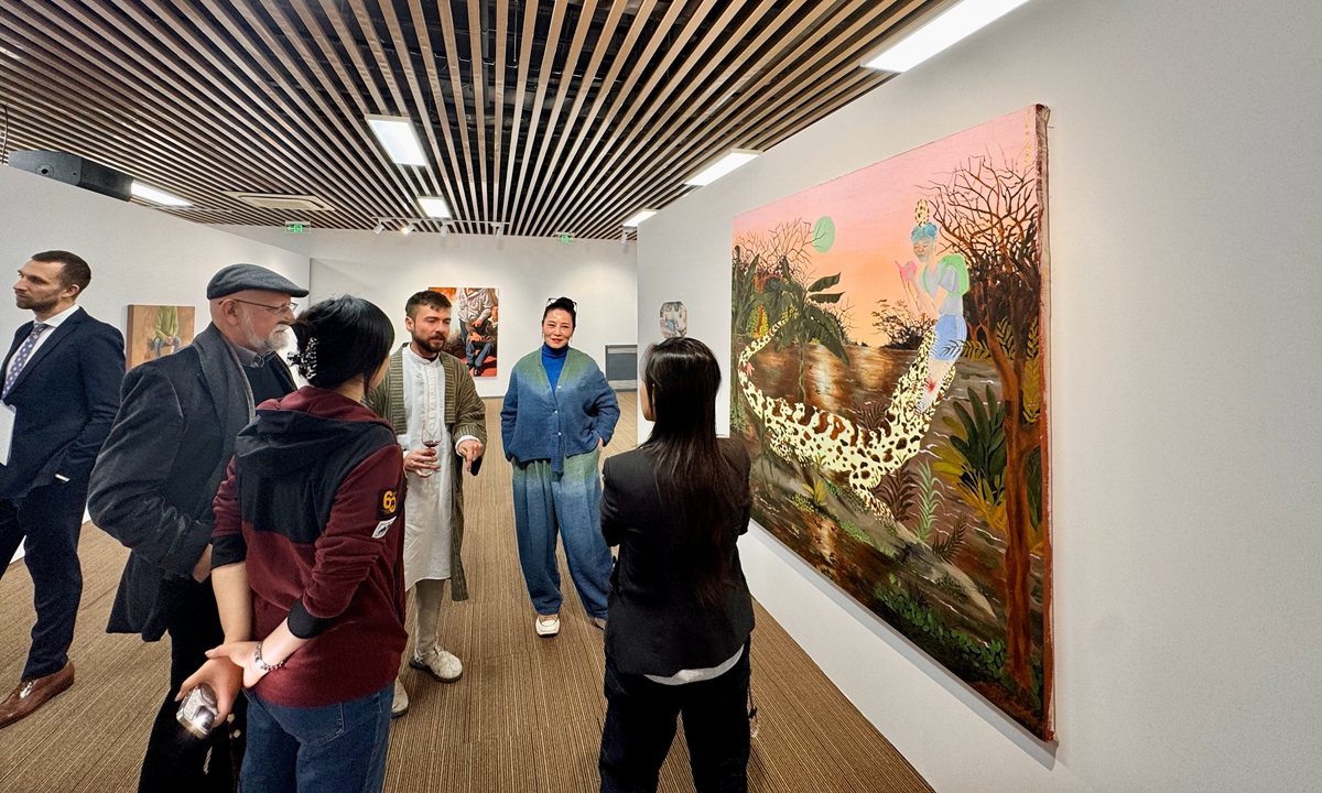 Javier Morales (3rd from right) discusses his paintings with visitors at the opening ceremony of the exhibition in Beijing on December 11, 2025.. Photo: Dong Feng/GT 