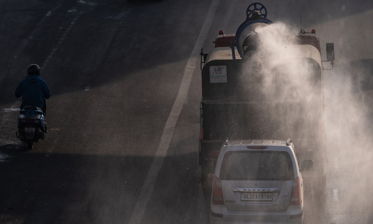 A municipal tanker spraying mist to curb air pollution passes along a road on December 3, 2025 in New Delhi, India. Photo: VCG