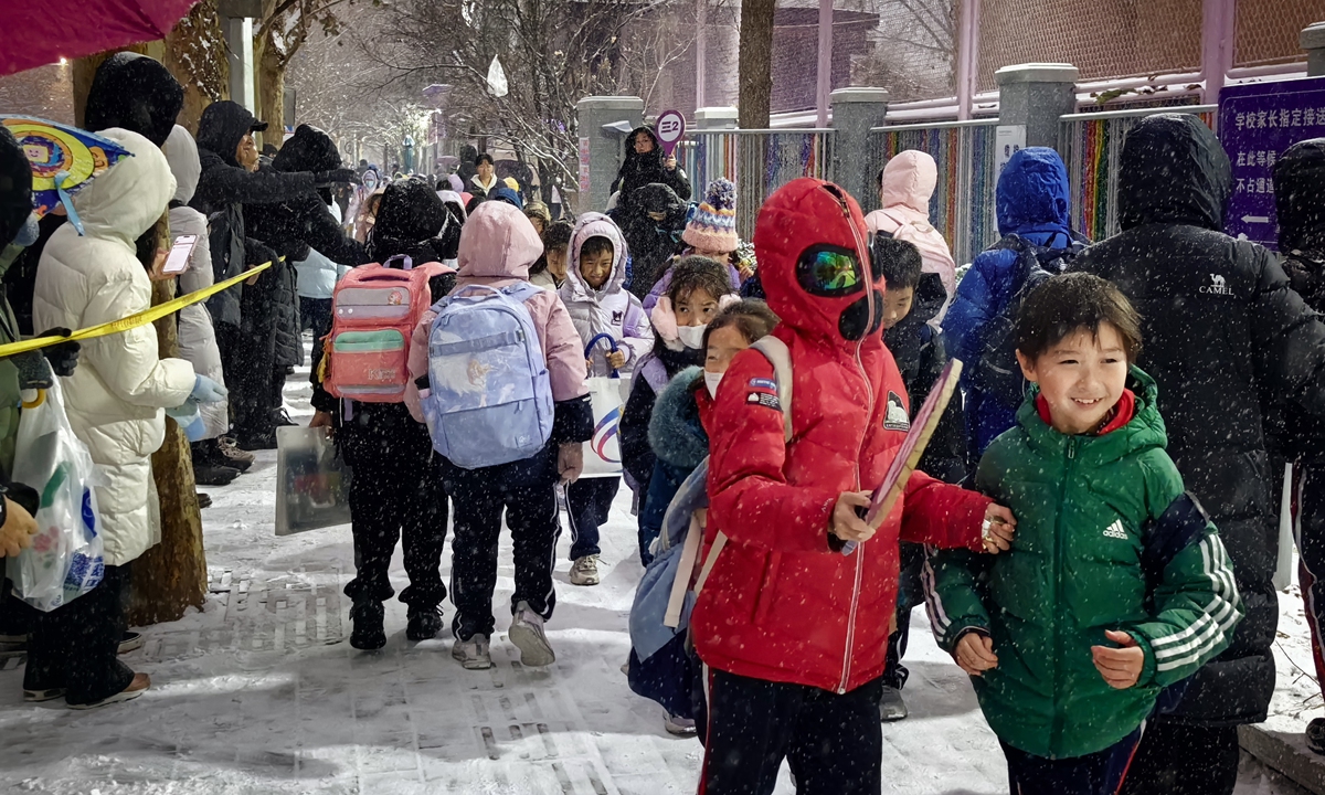 The photo shows primary school students from the Jiaming Branch of Chen Jinglun Middle School in Chaoyang District, Beijing, leaving school amid snowfall on December 12, 2025. On the day, widespread snowfall blanketed Beijing's urban areas. Photo: Liu Yang/GT