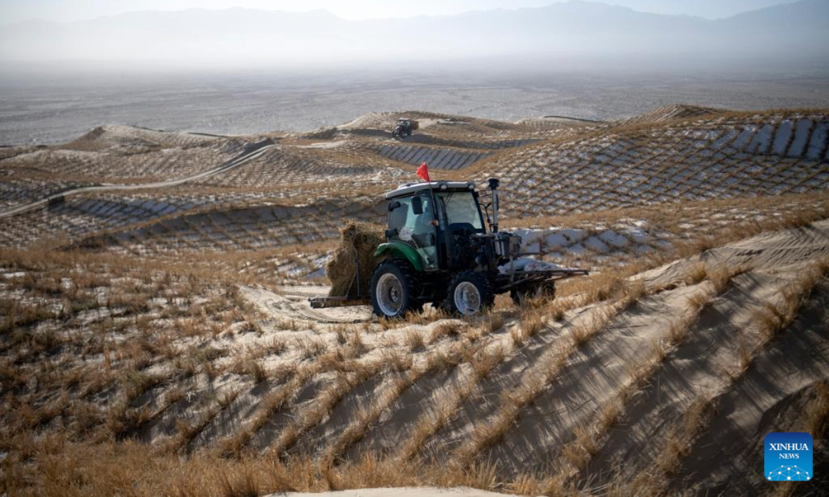 A staff member drives a tractor to transport materials for sand barriers in Kumtag Desert in Kazak Autonomous County of Aksay, northwest China's Gansu Province, Dec. 13, 2025. Covering a total area of 222,000 mu (14,800 hectares), a water conservation, ecological protection and restoration project is underway here, with sub-projects including sand fixation and afforestation. (Photo by Gao Hongshan/Xinhua)