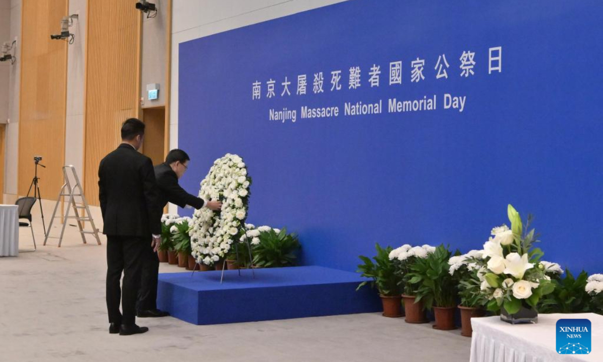 Chief Executive of the Hong Kong Special Administrative Region (HKSAR) John Lee (R) lays a wreath at a ceremony mourning the victims of the Nanjing Massacre in south China's Hong Kong, Dec. 13, 2025. (Information Services Department of the Government of the HKSAR/Handout via Xinhua)