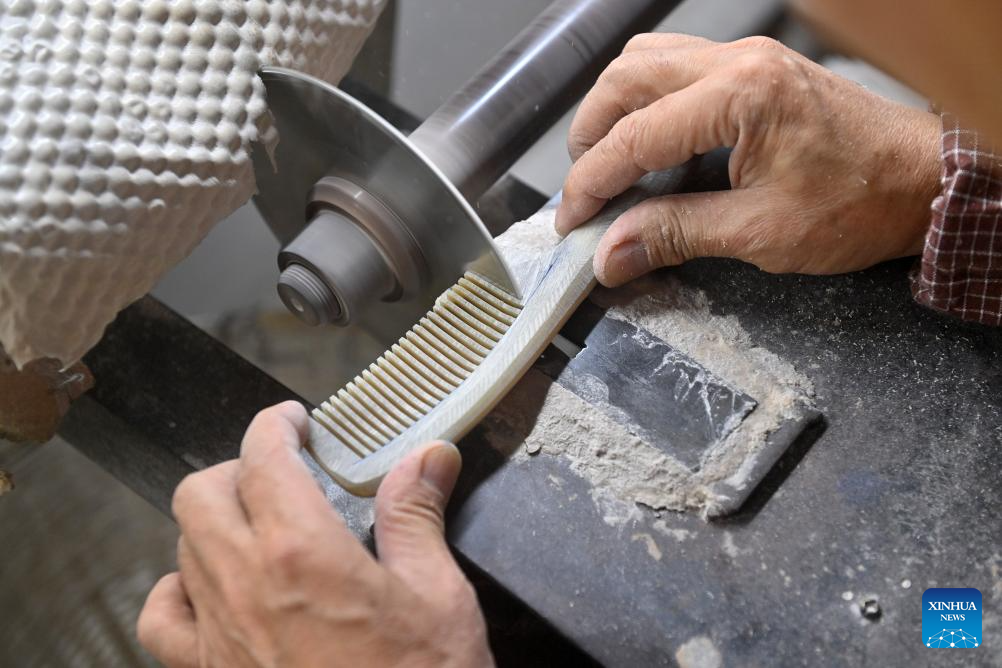 Ye Hualiang, an inheritor of the Wuling ox horn carving technique, works on an ox horn comb in Wuling Town of Binyang County, south China's Guangxi Zhuang Autonomous Region, Dec. 16, 2025. The Wuling ox horn carving technique of Binyang County is a local traditional craft with a history of over three centuries. In recent years, Binyang County has been encouraging industrial innovation in the development of ox corn products such as combs, massage hammers, tea sets and pen caps. Every year, some six million ox horn products are produced in the county with considerable market acceptance. (Xinhua/Lu Boan)