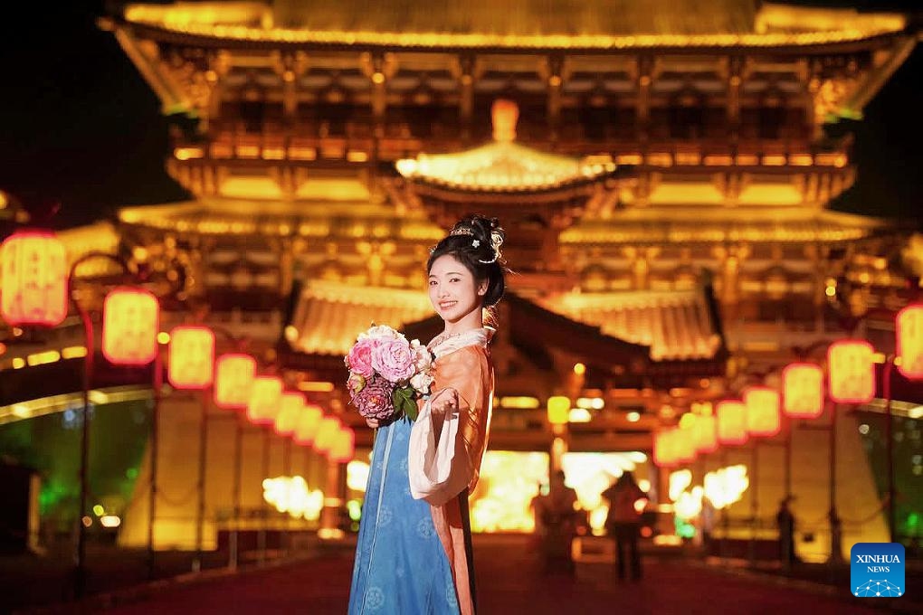 Vietnamese tourist Nguyen Quynh Chi wearing Hanfu, a traditional Chinese attire, poses for photos in Luoyang, central China's Henan Province, April 26, 2025. (Xinhua)