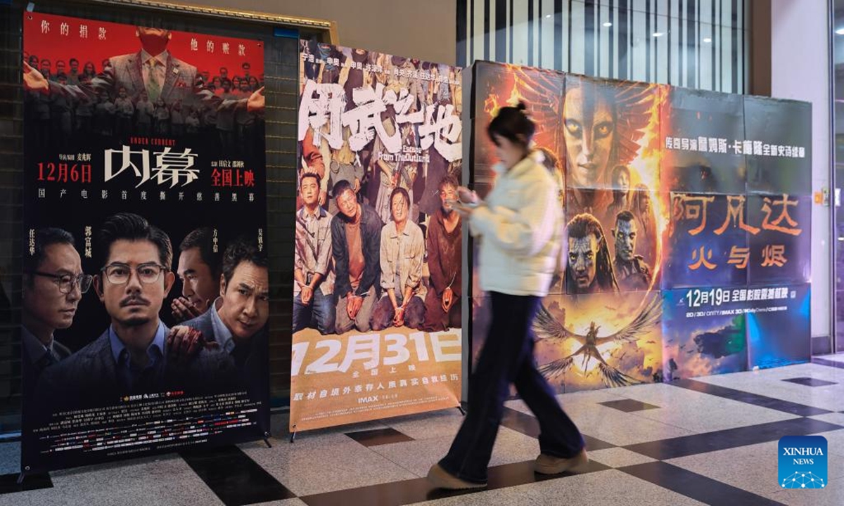 A woman walks past movie posters at a movie theater in Nanjing, east China's Jiangsu Province, Dec. 13, 2025. As of 2:30 p.m. on Saturday, China's 2025 box office revenue had surpassed 50 billion yuan (about 7.08 billion U.S. dollars), according to the China Film Administration. (Photo by Su Yang/Xinhua)