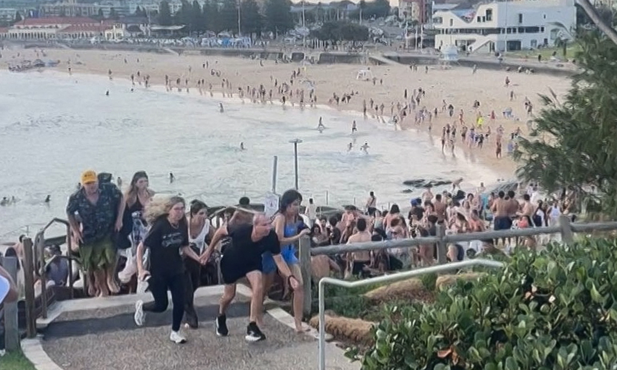 Screenshot of a video at the courtesy of Mike Ortiz shows beach-goers fleeing Bondi Beach after gunmen opened fire, in Sydney on December 14, 2025. Suspected shooters opened fire at Sydney's iconic Bondi Beach, killing at 12 people and wounding multiple others. Photo: AFP