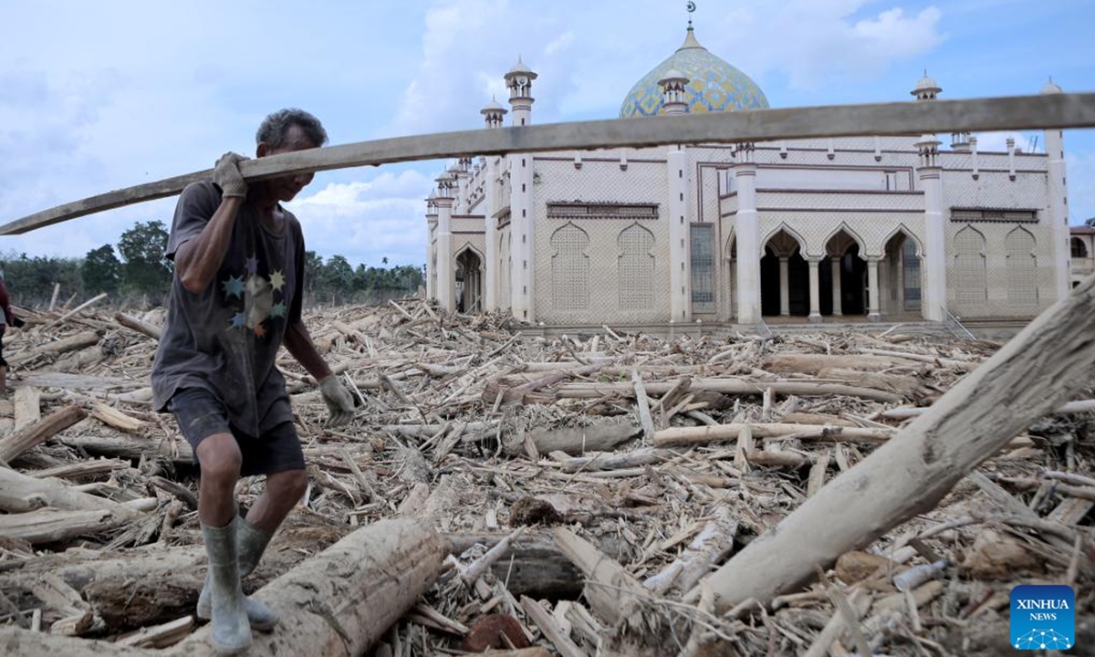 A villager moves timber amid debris after floods and landslides hit Aceh Tamiang regency in Aceh, Indonesia, Dec.10, 2025. The death toll from floods and landslides that struck three provinces on Indonesia's Sumatra Island has exceeded 1,000, with 218 people still missing, according to the latest data released Saturday by the National Disaster Management Agency (BNPB). (Photo by Gatha Ginting/Xinhua)
