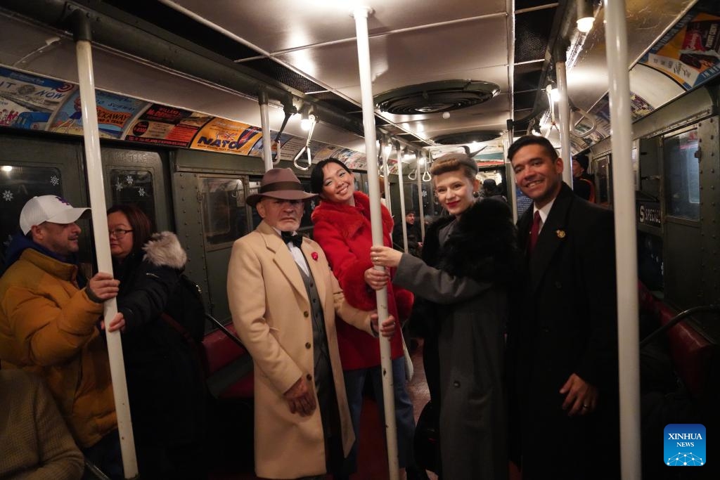 People in vintage clothing pose in front of the Holiday Nostalgia Train in New York City, the United States, on Dec. 14, 2025.
Holiday Nostalgia Train, vintage 1930s train cars, is running every Sunday in December to celebrate the holiday season here in New York, taking passengers to step back in time. (Xinhua/Zhang Fengguo)